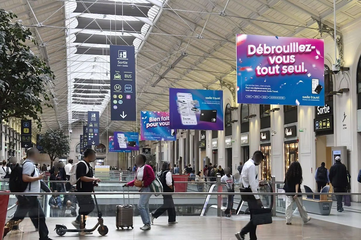 Hall de gare avec les affiches Swile Travel.